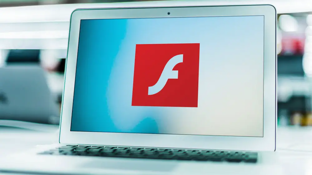 Una computadora portátil con el logo de Flash en la pantalla.